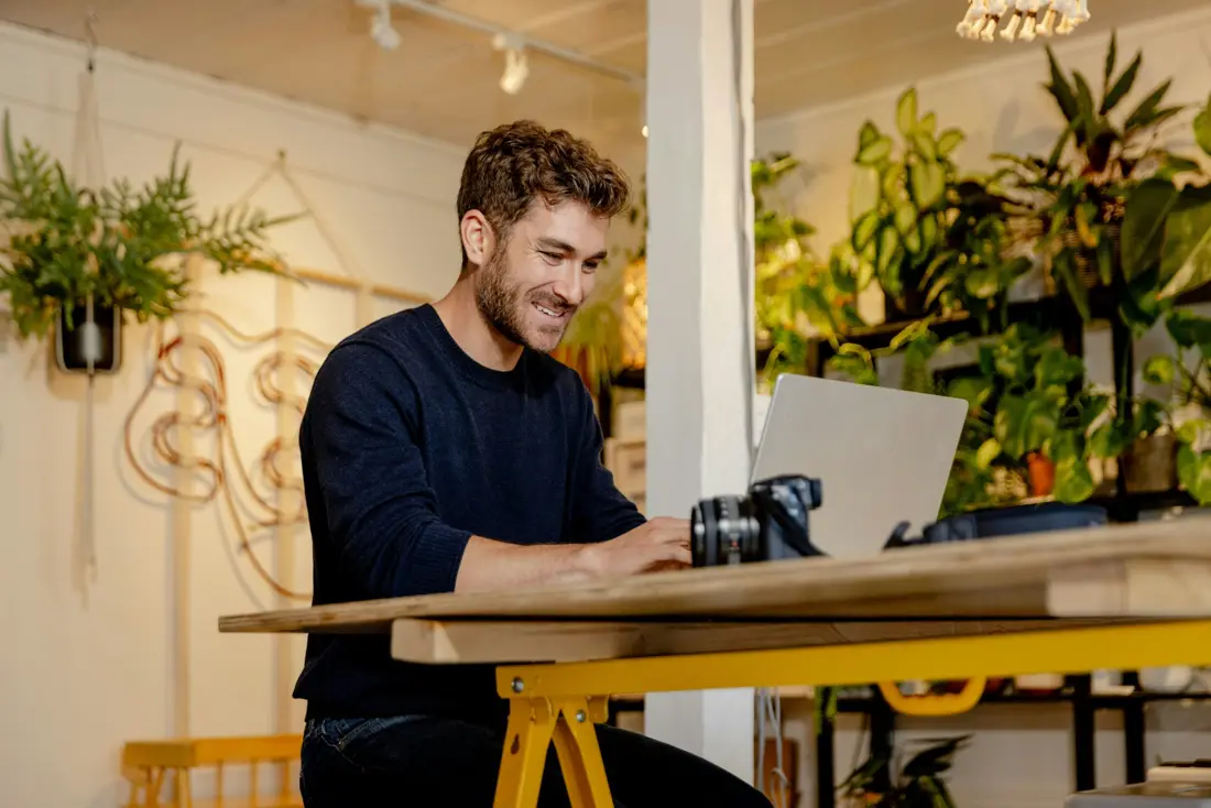 A small business owner editing on a laptop